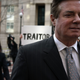 Former Trump campaign manager Paul Manafort leaves the Albert V. Bryan U.S. Courthouse with his wife Kathleen Manafort (L) after an arraignment hearing as a protester holds up a sign March 8, 2018 in Alexandria, Va.